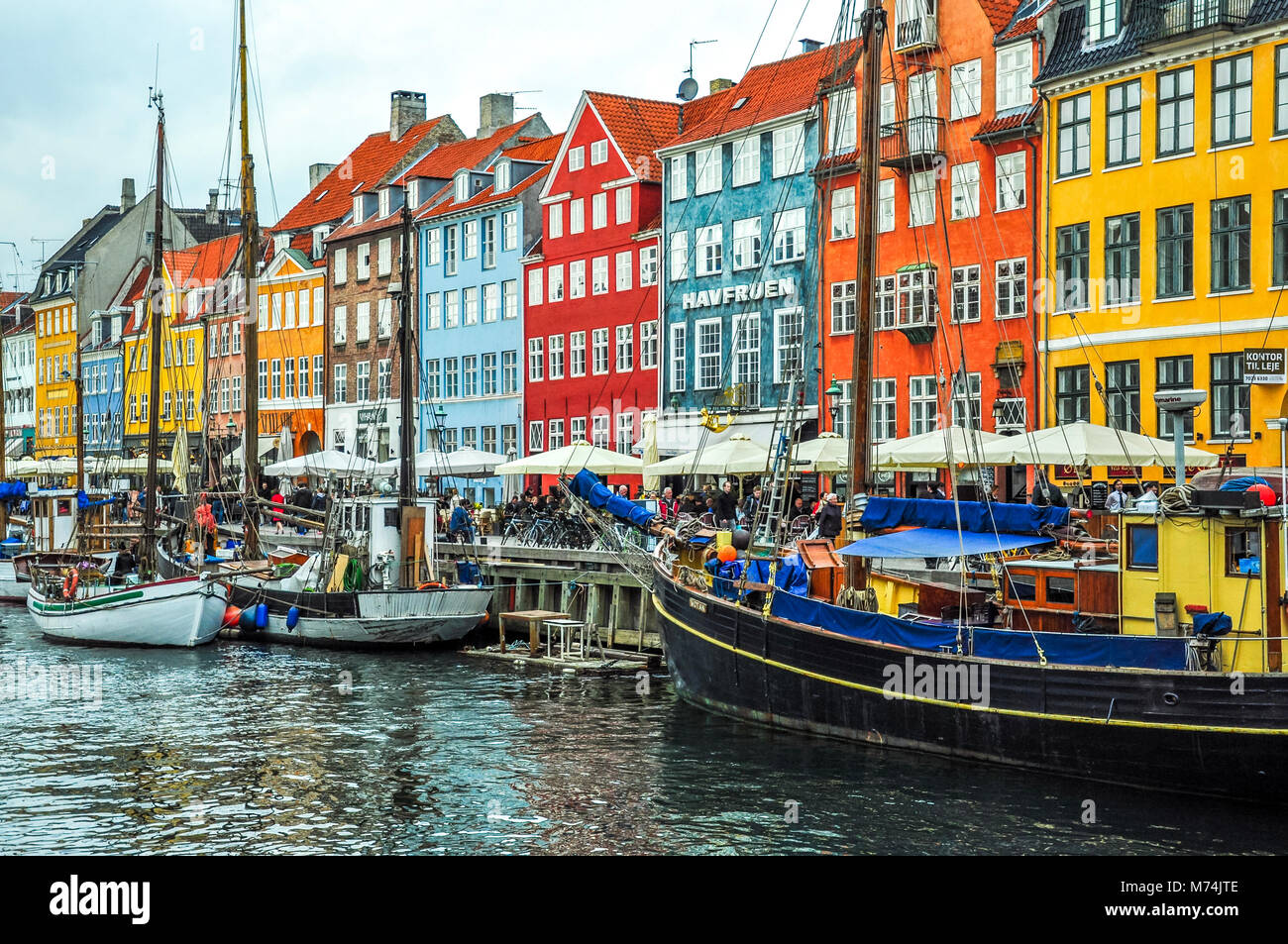 Kopenhagen, Dänemark - 20 April 2012, bunte Hafenviertel Nyhavn und den Kanal mit Booten und Menschen zu Fuß und Essen Stockfoto