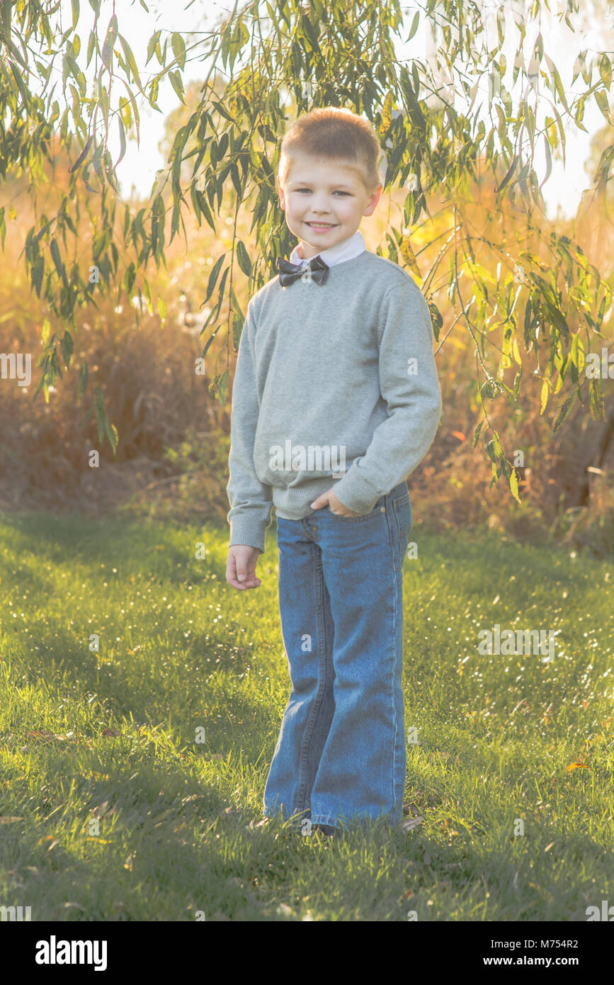 Sieben Jahre alten Jungen spielen im Freien im Herbst Stockfoto