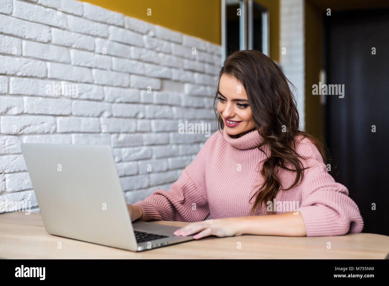 Lächelnde Frau mit Laptop im Büro zu Hause Stockfoto