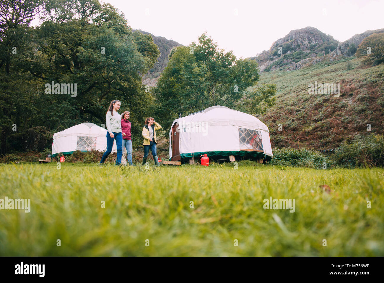 Drei generation Familie kehren zurück zu Ihren camping Jurte nach einer langen Wanderung zusammen. Stockfoto