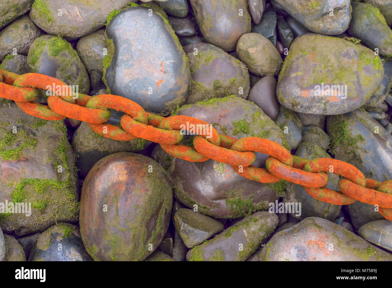 Schweren Gewichts rostigen Ketten über Kiesel und Steine im Hafen Stockfoto