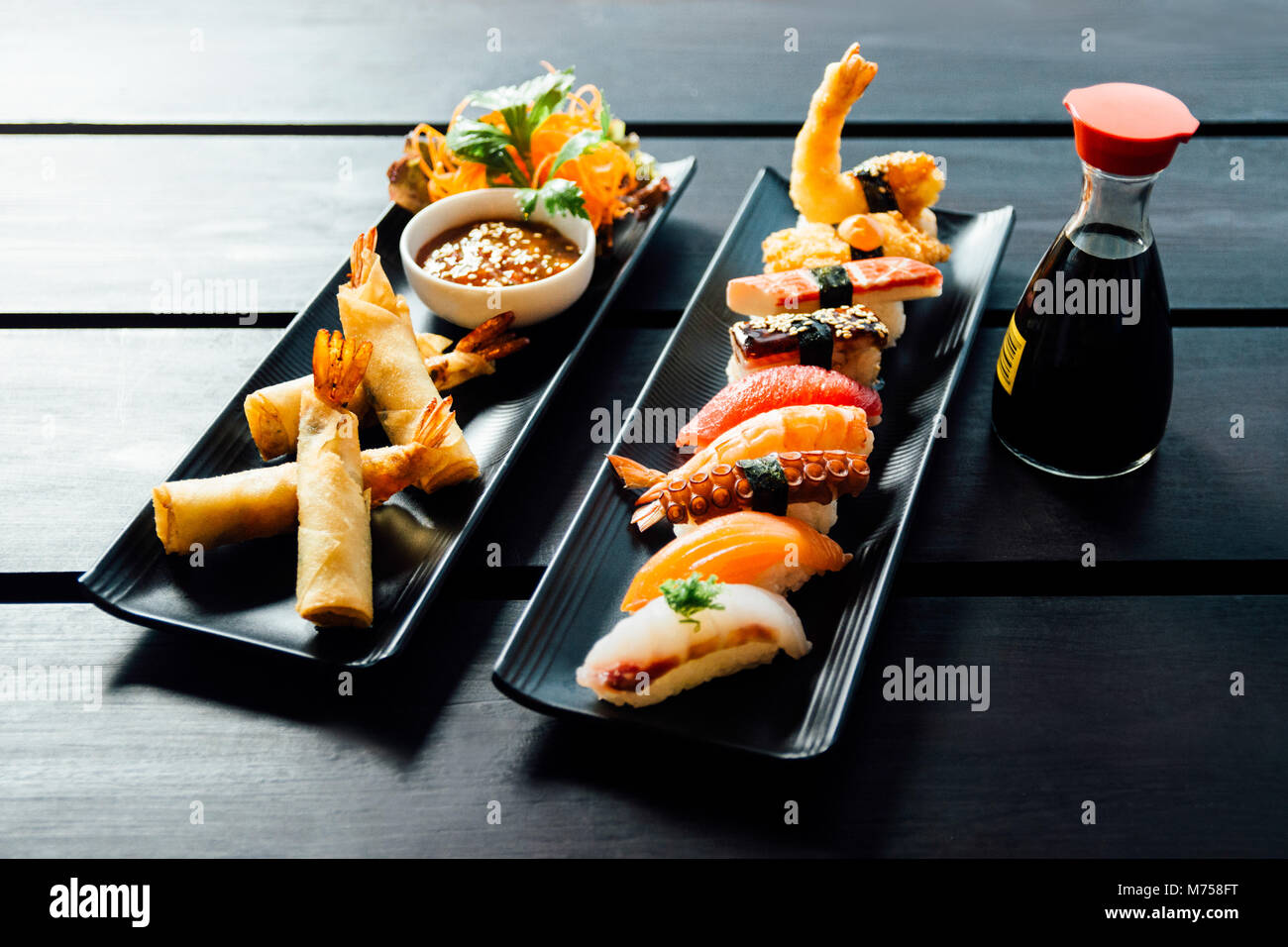 Verschiedene Arten von Sushi serviert auf schwarzem Stein Stockfoto