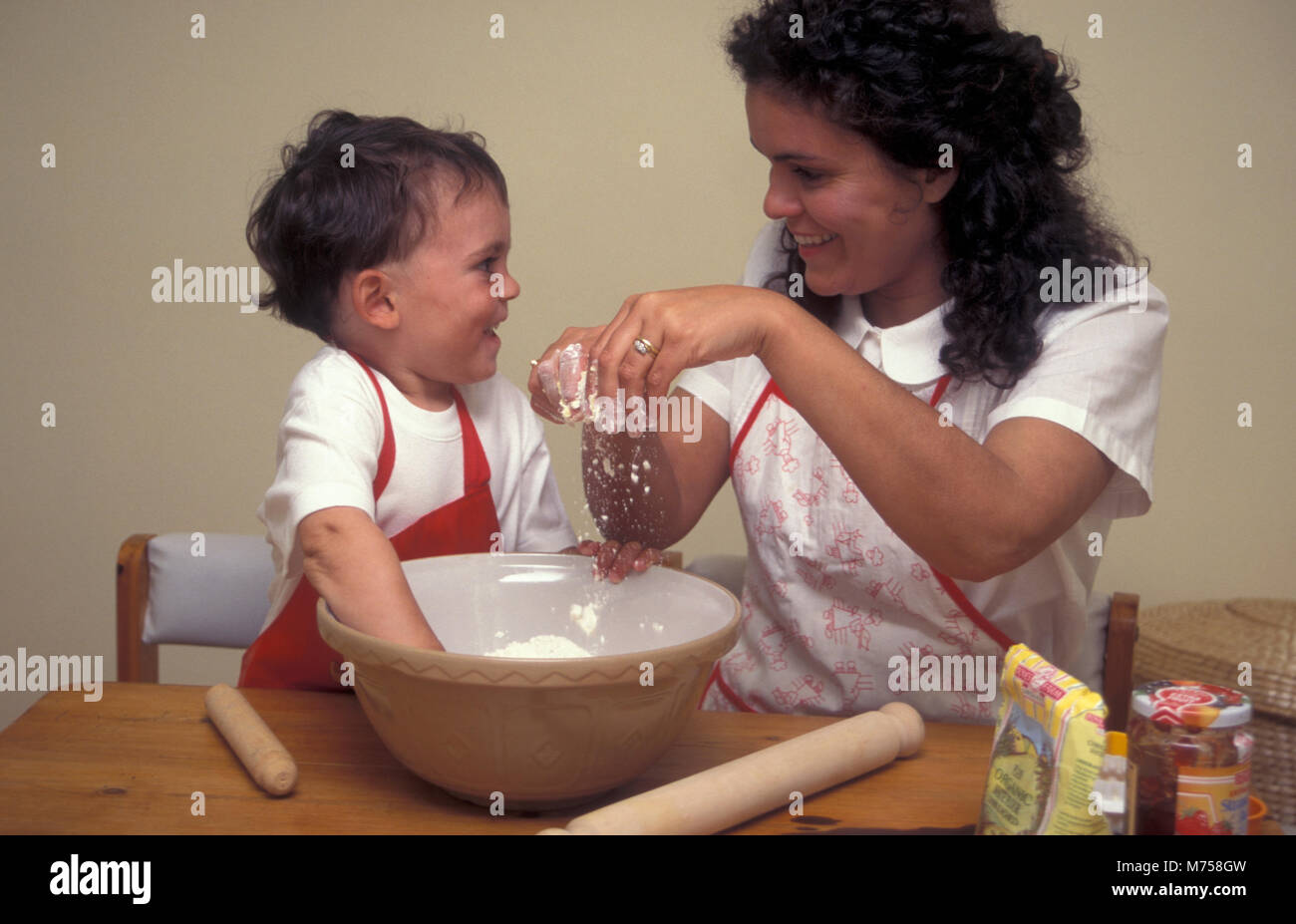 Mutter und Kleinkind, marmeladentörtchen zusammen Stockfoto
