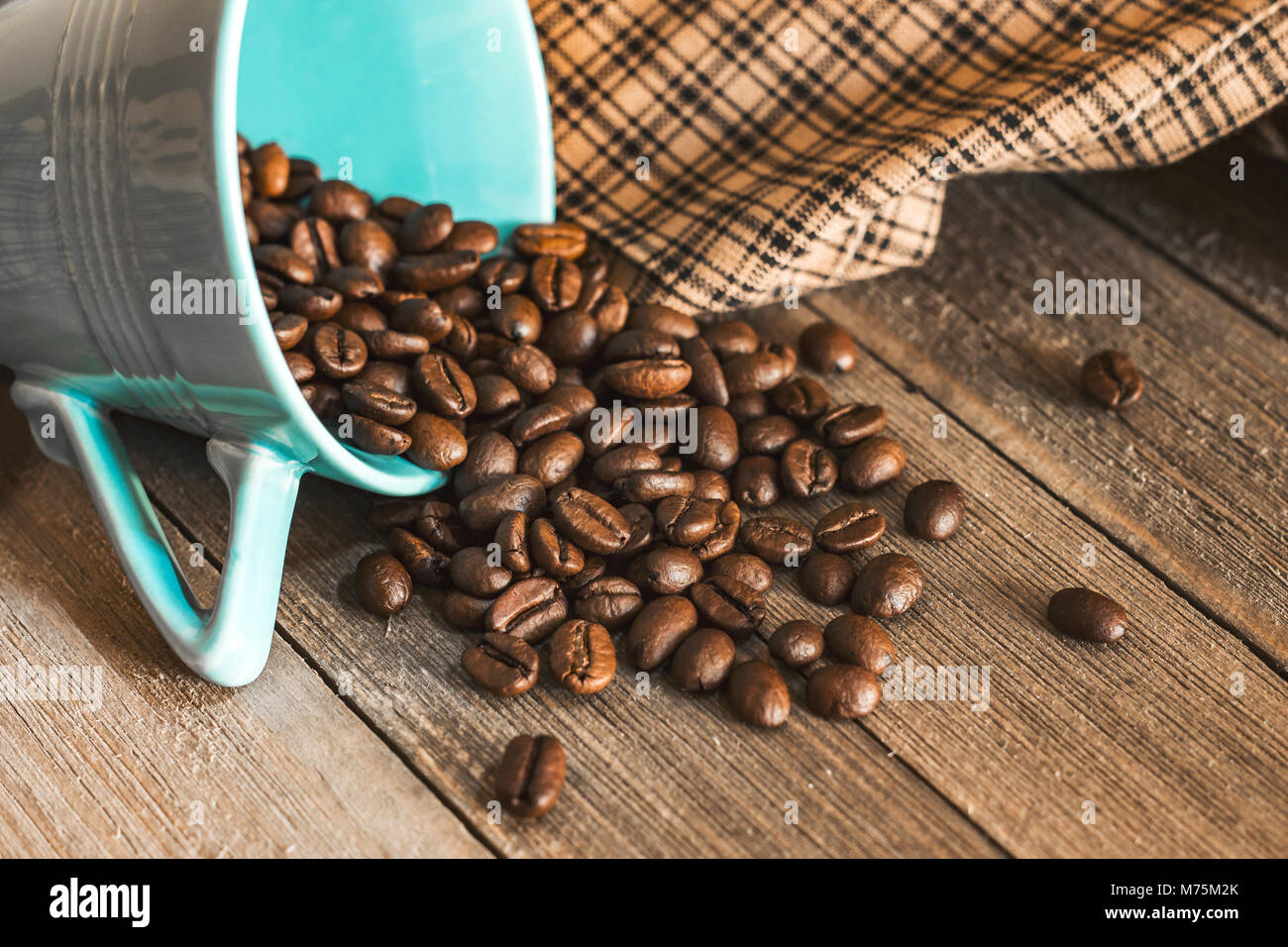 Kaffee Bohnen Verschütten aus einem blauen Tasse Tee. Stockfoto