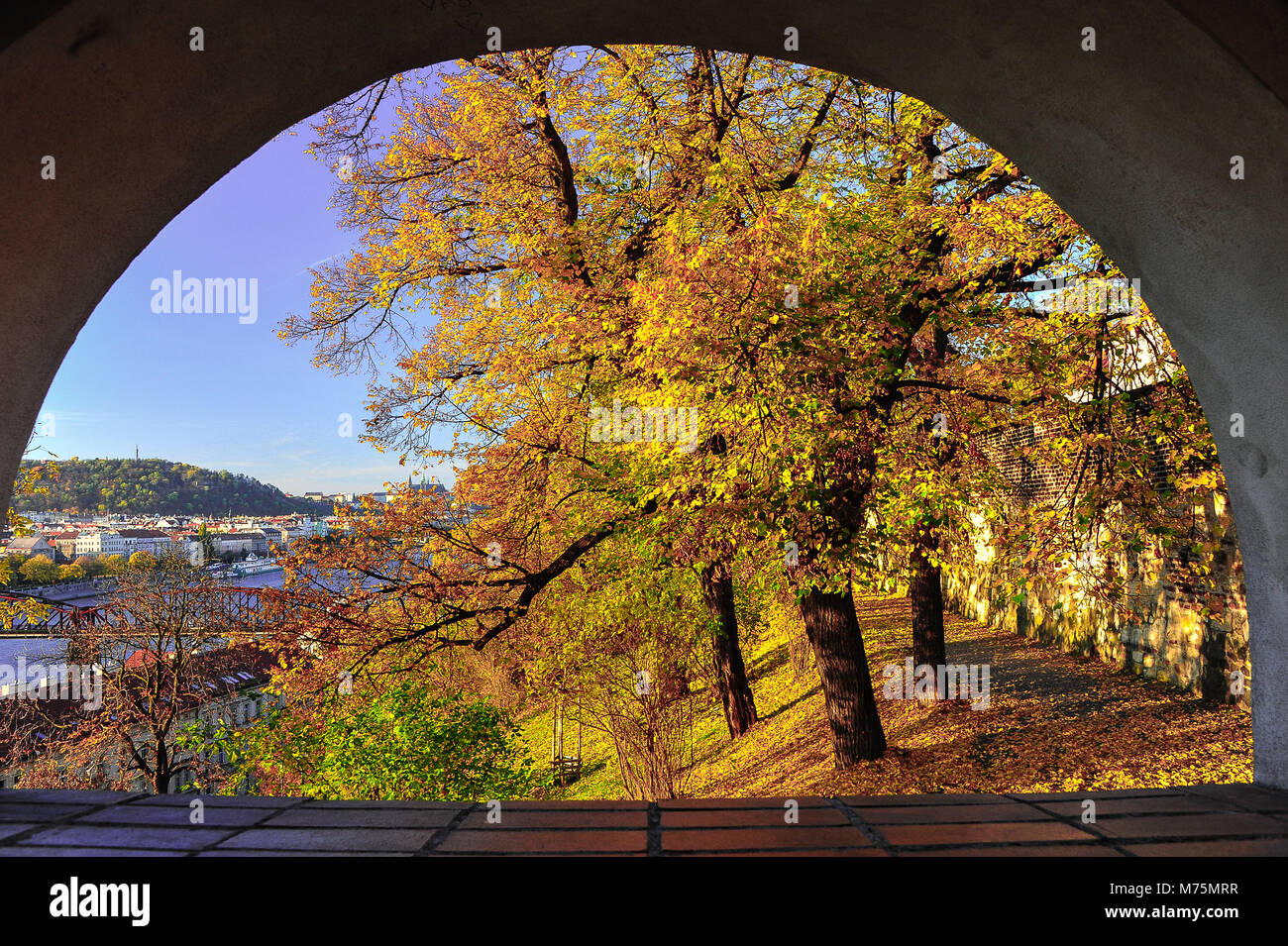 Herbst durch einen Torbogen. Einen malerischen Blick auf den Fluss Vitava und Prag von Vysehrad. Schöne Szene, Gold und rotbraun Laub gegen den blauen Himmel Stockfoto