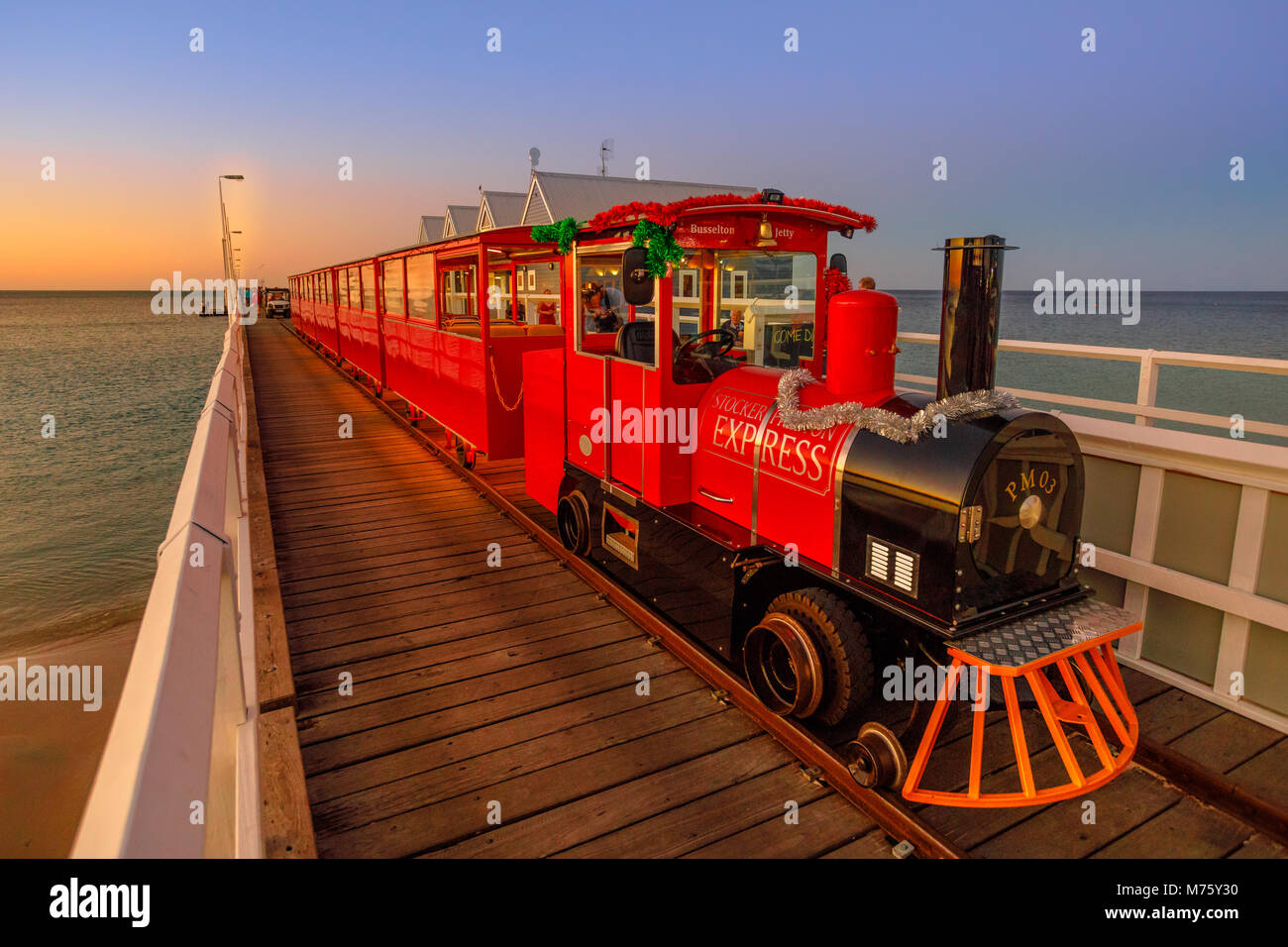 Busselton, Australien - 30 Dezember 2017: Busselton Jetty Zug auf der längsten hölzernen Pier Titel in der Welt erstreckt sich fast 2 km zum Meer. Malerische iconic in Western Australia in der Dämmerung Stockfoto