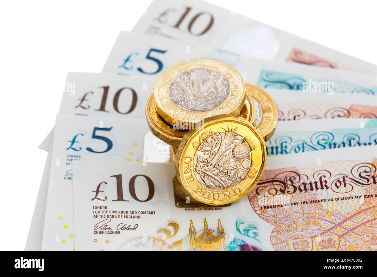 Stapel der Britischen 12 seitige £ ein Pfund Münzen Geld Pfund Bargeld auf neue Polymer Kunststoff £ 10 und £ 5 Noten GBP Ausschnitt auf Weiß. England Großbritannien Großbritannien Stockfoto