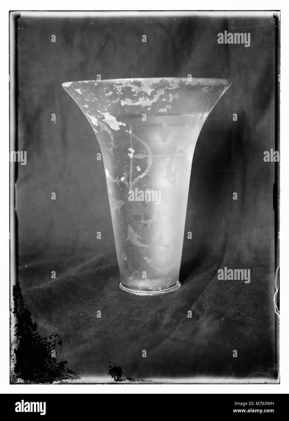 Ein Nahaufnahme eines antiken Glasstücks, das die Handwerkskunst und das komplizierte Design älterer Glaswaren zeigt. Das Bild zeigt die Schönheit der historischen Glasproduktion. Stockfoto