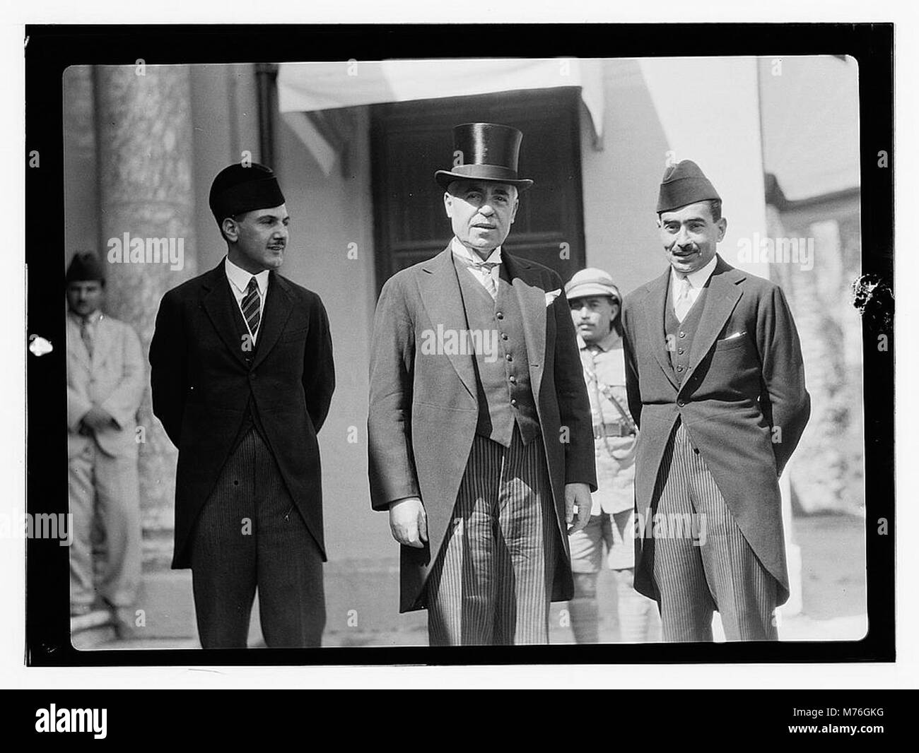 Dieses Bild vom 6. Juni 1932 zeigt einen Mann in einem Tophut mit anderen Männern in formellen Schwänzen bei einer Palastveranstaltung in Bagdad. Das Foto spiegelt die Pracht und formale Kleidung der Zeit wider und hält einen wichtigen gesellschaftlichen Anlass fest. Stockfoto