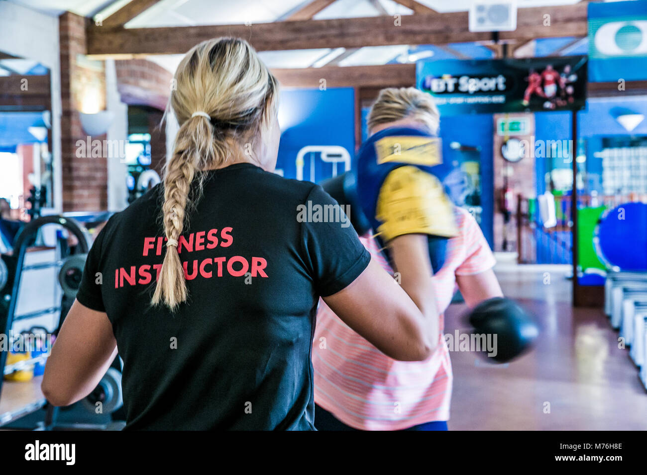 Weibliche Fitness Instructor Boxen mit weiblichen Kunden. In einer Eins-zu-eins Training im Fitnessraum Stockfoto