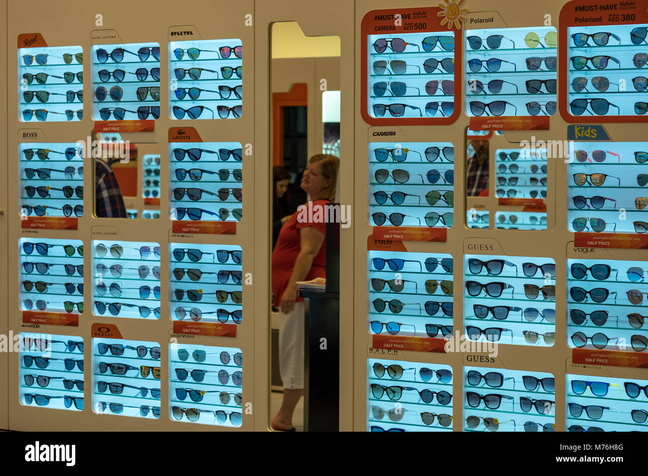 Eine alte Frau in einen Spiegel, an der Optik bei Yas Mall auf der Suche Stockfoto