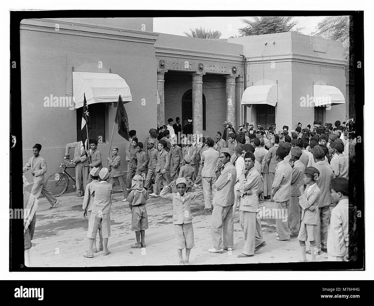 Dieses Foto zeigt eine Parade am 6. Oktober 1932 in Bagdad. Die Prozession ist Teil einer öffentlichen Feier, die die kulturelle und politische Atmosphäre der Zeit im Irak widerspiegelt. Stockfoto