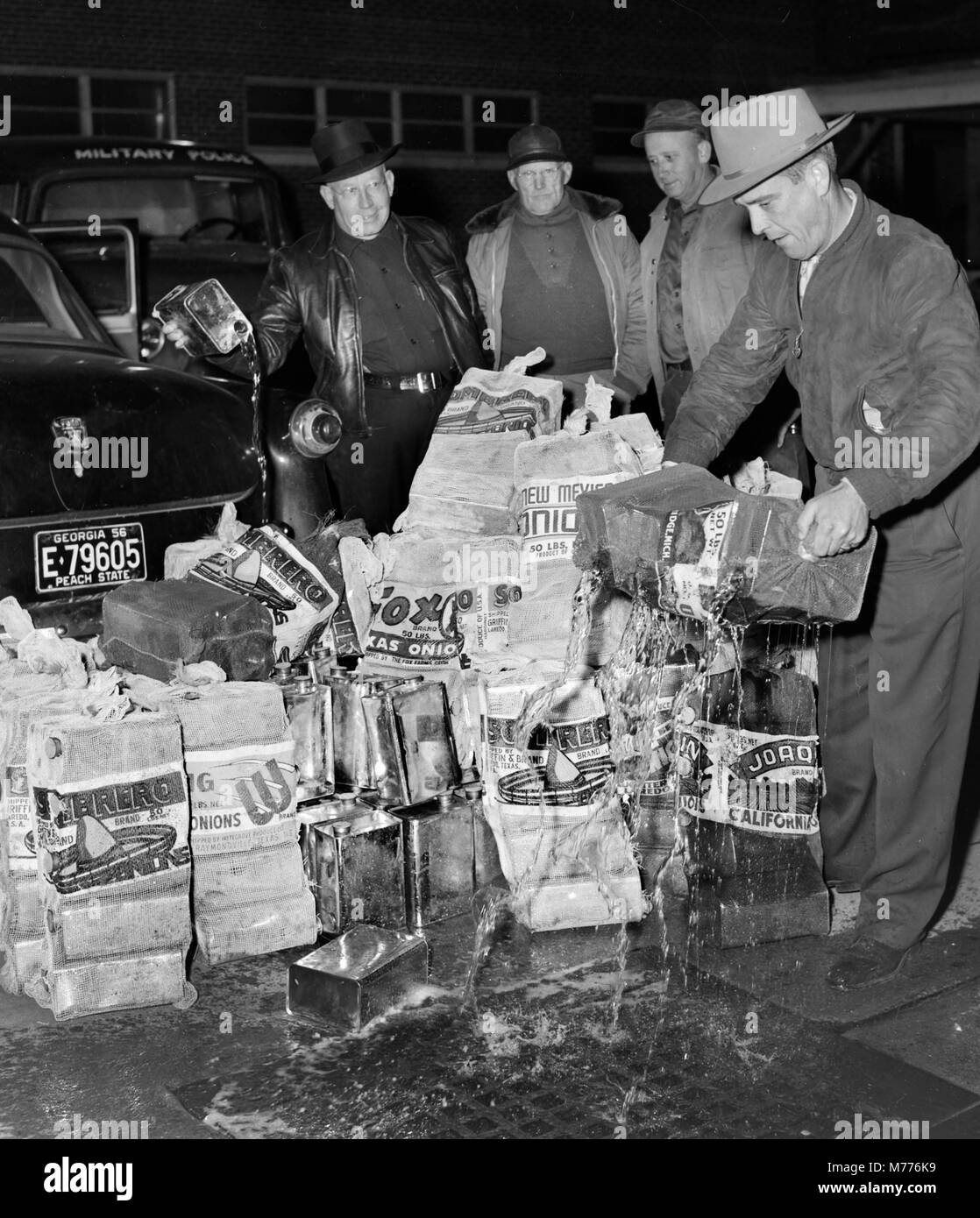 Polizei leer einen Stash der illegalen moonshine Likör in eine Straße ablassen im US-Bundesstaat Georgia in 1957. Stockfoto
