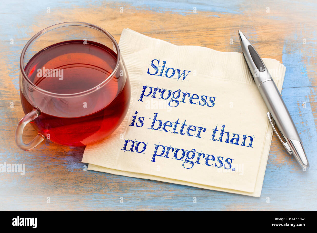 Langsame Fortschritte ist besser als keine Fortschritte inspirational Hinweis - Handschrift auf eine Serviette mit einer Tasse Kaffee Stockfoto