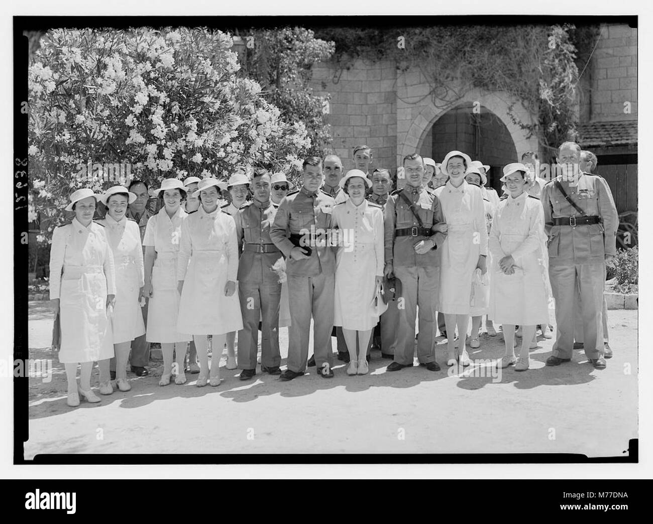 Eine Hochzeitsgruppe versammelte sich am 3. Juni 1942 im Garten eines Hostels in der Nähe der St. George's Cathedral, um die Braut und ihre Begleiter in einer Nahaufnahme zu erfassen und dabei die Hochzeitstraditionen und Kleidung der Mitte des 20. Jahrhunderts zu zeigen. Stockfoto