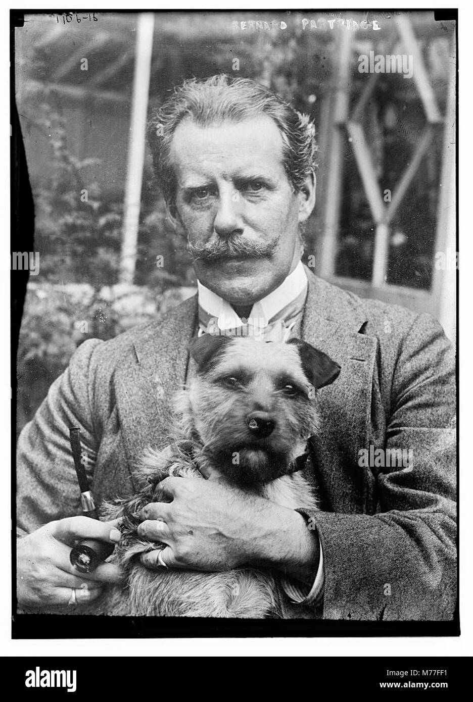 Bernard M. Partridge, eine prominente Figur, ist in diesem Porträt mit einem Hund dargestellt. Das Bild fängt einen Moment der persönlichen Verbindung ein und zeigt die Beziehung zwischen dem Individuum und dem Tier. Stockfoto