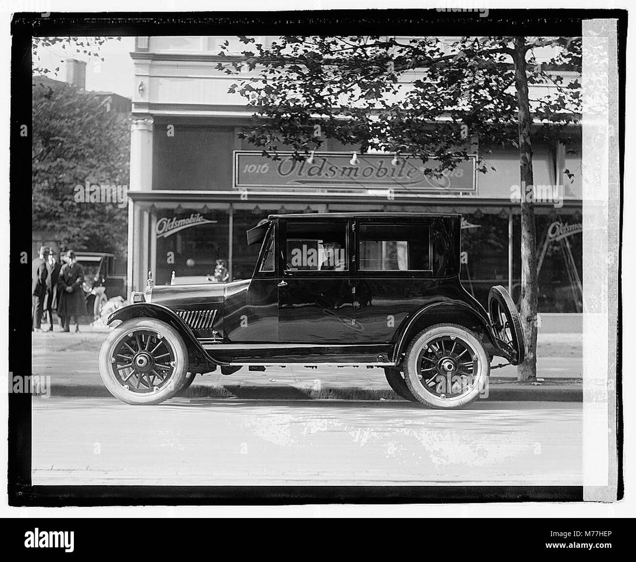 Foto eines Schwarzen Individuums in einem Oldsmobile, das die afroamerikanische Präsenz in der Automobilgeschichte repräsentiert. Stockfoto