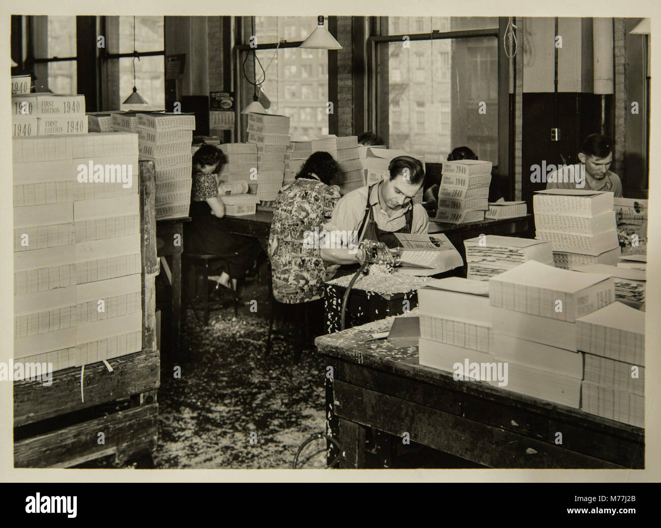 Ein Foto, das den Buchbinderungsprozess in einer Buchherstellungsanlage aufnimmt und das Handwerk des Buchbinderns als integralen Bestandteil der Verlagsbranche hervorhebt. Stockfoto