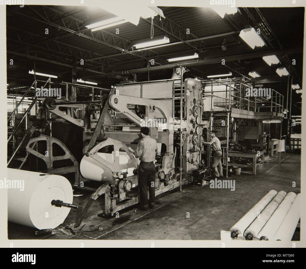 Das Bild zeigt den Prozess der Buchherstellung mit einer Offsetpresse, einer wesentlichen Technologie in der Druckindustrie, die die Produktion von Büchern und Drucksachen revolutionierte. Stockfoto