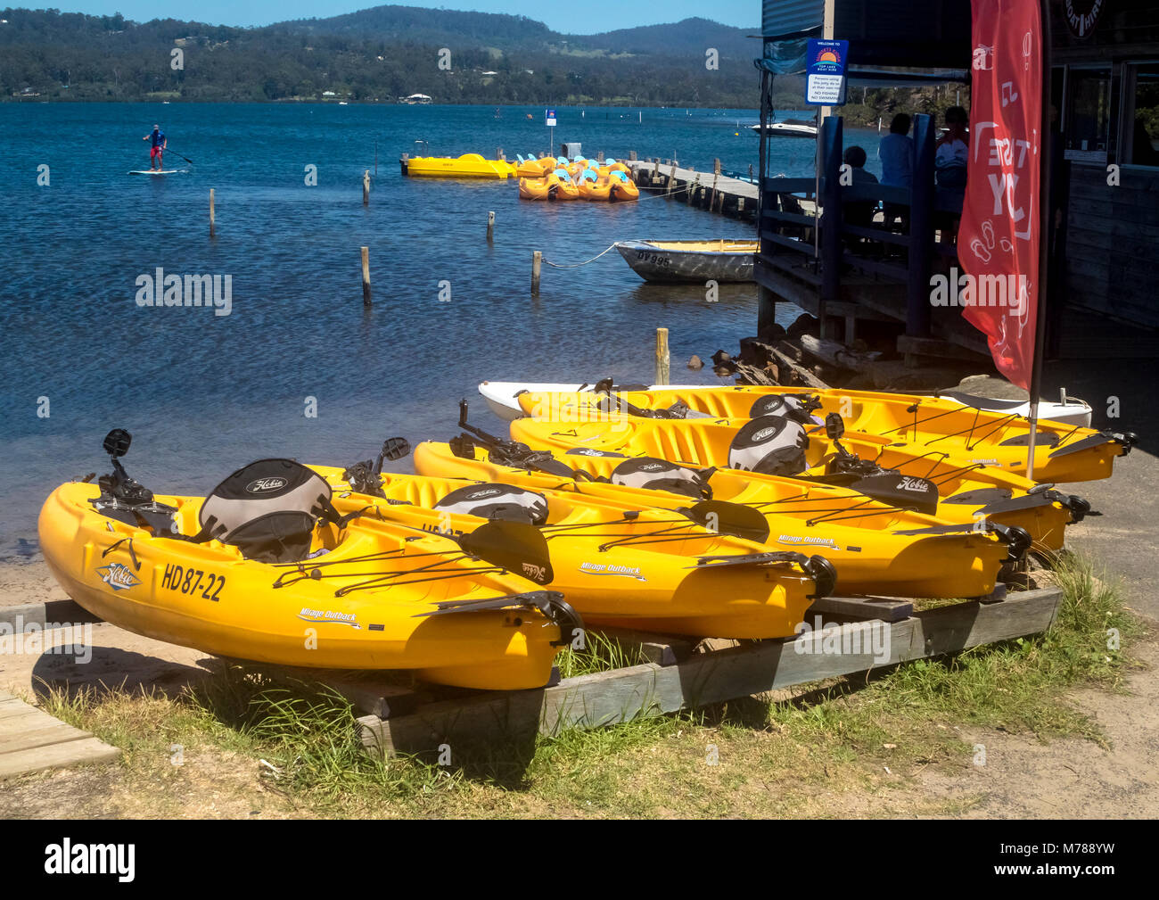 Kajaks und Tretboote mieten in Merimbula top See an der Südküste von New South Wales in Australien bereit, während Paddel boarder das Wetter genießt Stockfoto