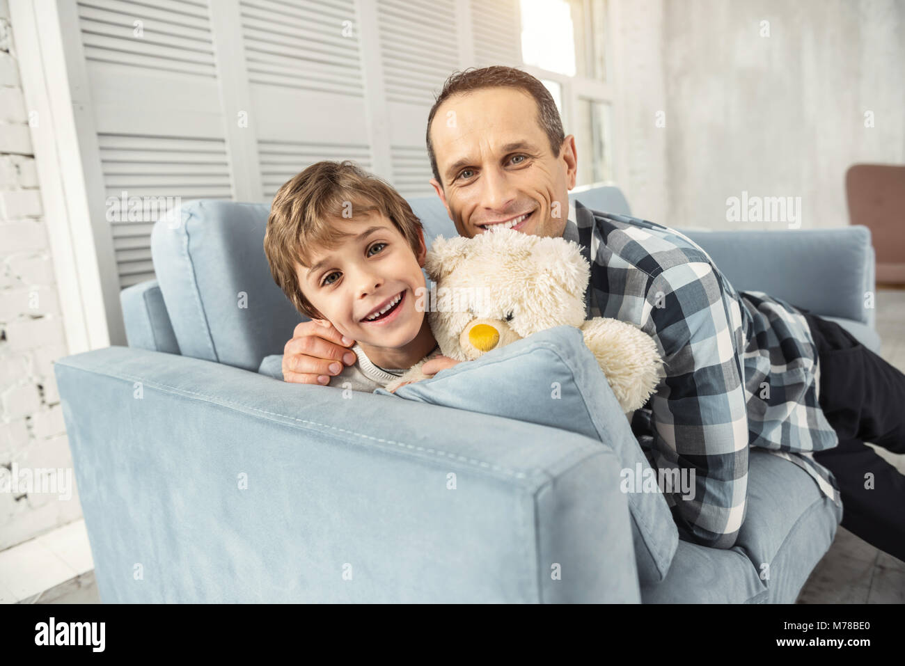 Gerne Vater umarmt seinen lächelnden Sohn Stockfoto