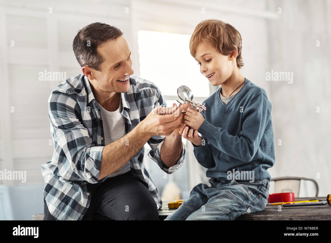 Freudige Vater, der seine Instrumente zu seinem Sohn Stockfoto