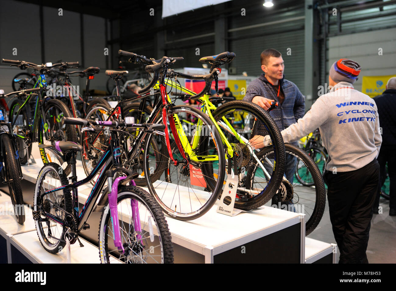 Zwei Besucher in der Nähe von Stand mit elektrische Fahrräder während der Ausstellung PLUG-IN DER UKRAINE 2018. März 2, 2018. Kiew Expo Center. Kiew, Ukraine Stockfoto