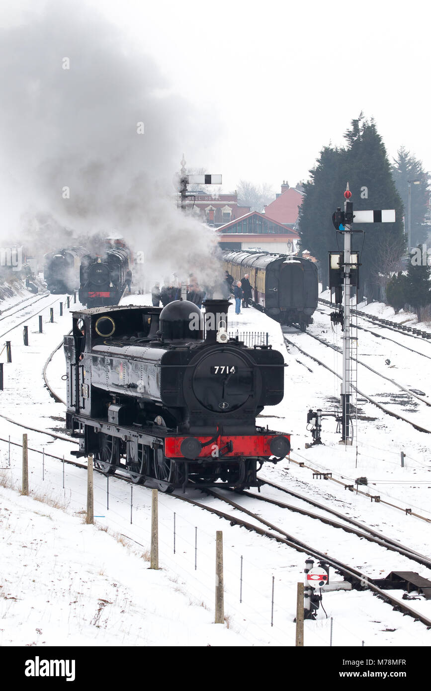 Die Severn Valley Railway Lokomotive 7714 schnaufend schneebedeckten Titel, Abfahrt von Kidderminster Station auf einem Bitterkalten morgen März, 2018. Stockfoto