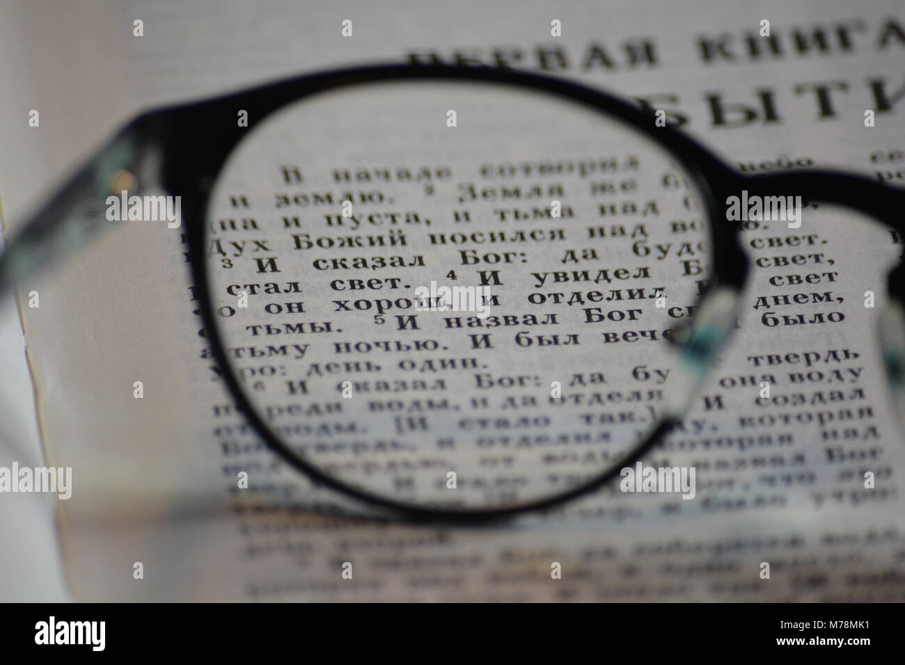 Lesebrille auf der Orthodoxen Bibel, die ersten Verse der Genesis sichtbar Stockfoto