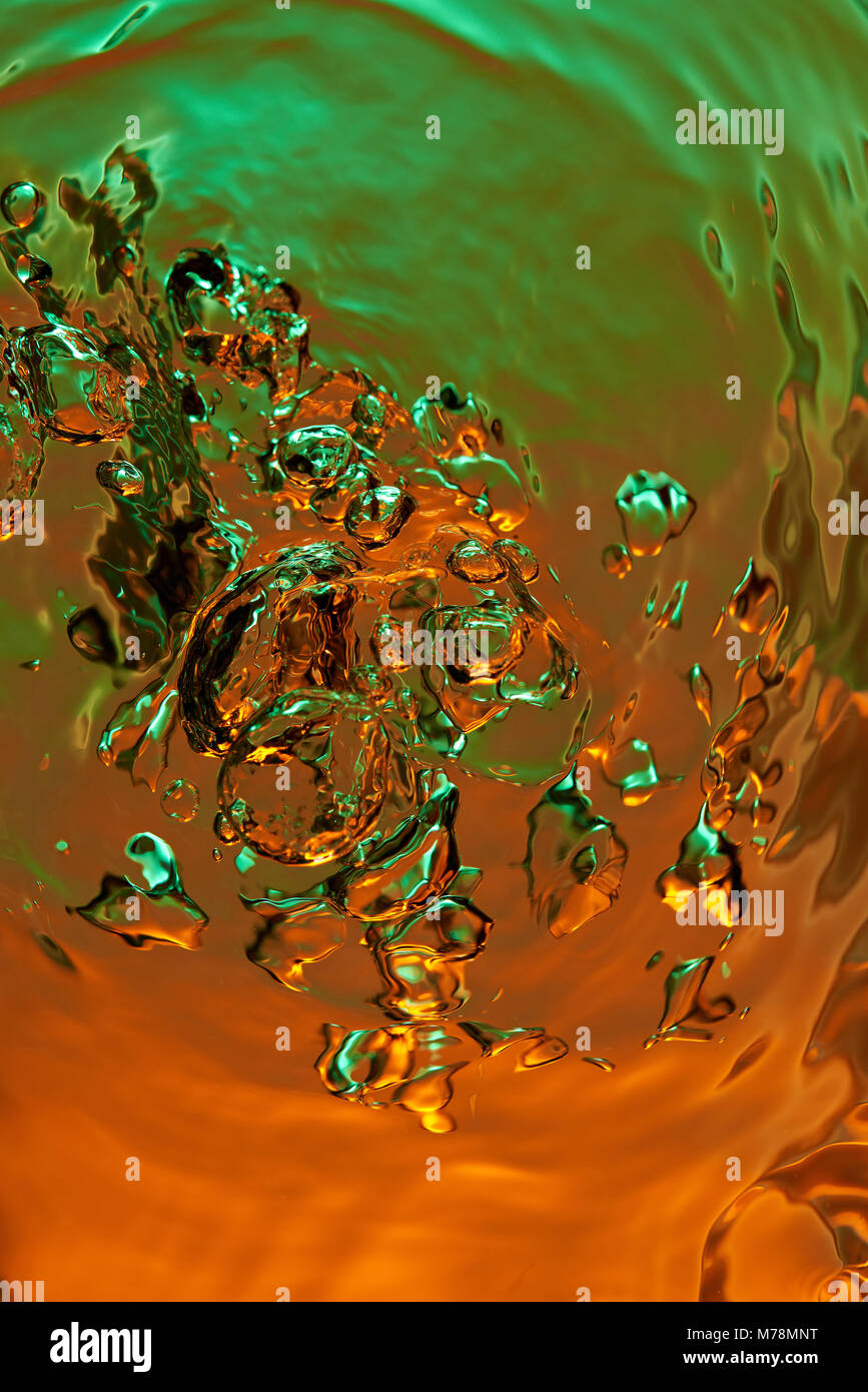 Abstrakte Luftblasen auf flüssigen Hintergrund. Bunte orange grün klares Wasser Oberfläche Stockfoto