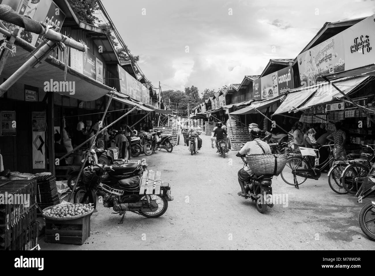 Straße in Nyaung U lokalen traditionellen asiatischen Markt mit birmanischen Volkes auf Motorrädern mit können Warenkorb Lagerung Güter kaufen, Bagan, Myanmar, Birma, Se Asien Stockfoto