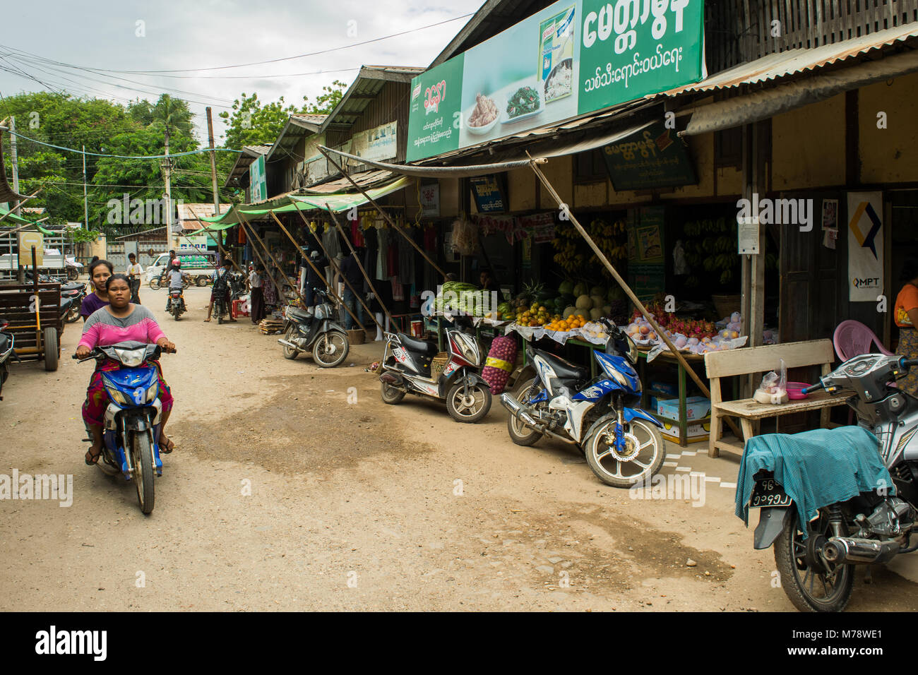 Zwei burmesische Frauen auf einem Motorrad Fahrrad in Nyaun U lokale im Freien Markt neben Obst und Gemüse, Bagan Myanmar Südostasien Stockfoto