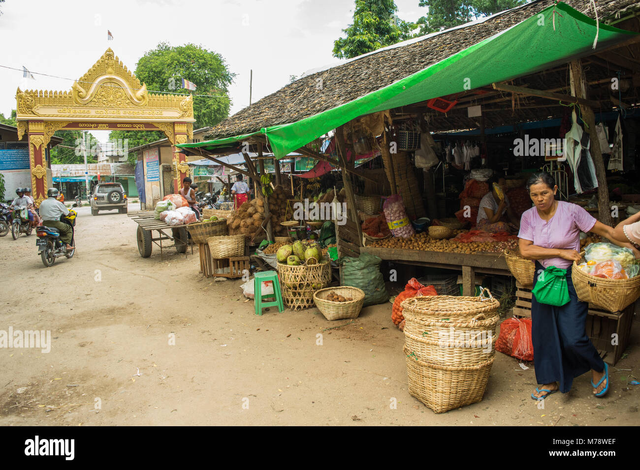 Die BURMESISCHE asiatischen Markt Nyaung U in der Nähe von Bagan, Myanmar. Marktstand verkaufen Obst, Gemüse und Nüsse Frau, die ihr Zuckerrohr Korb zu Burma. Stockfoto