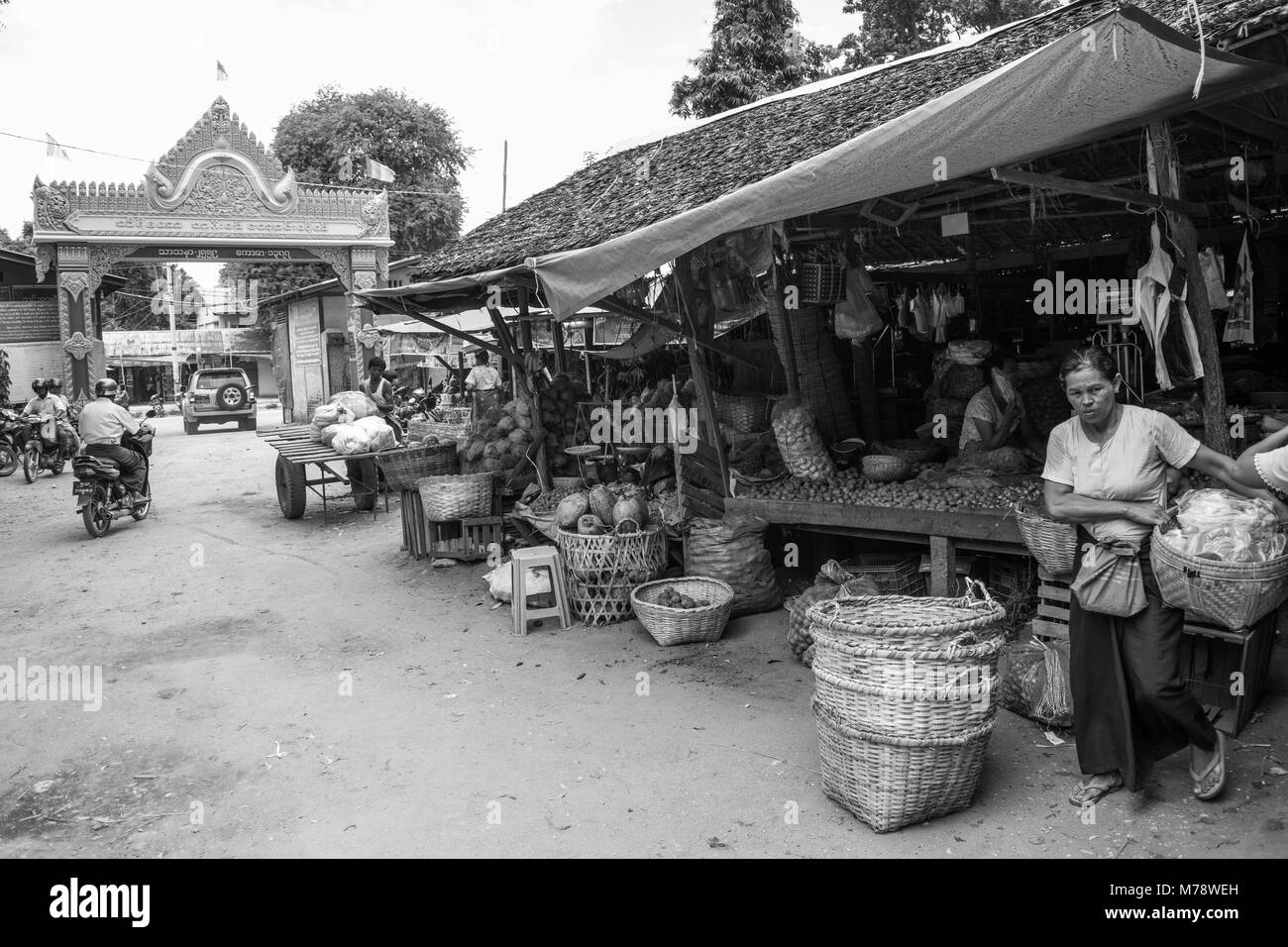 Die BURMESISCHE asiatischen Markt Nyaung U in der Nähe von Bagan, Myanmar. Marktstand verkaufen Obst, Gemüse und Nüsse Frau, die ihr Zuckerrohr Korb zu Burma. Stockfoto