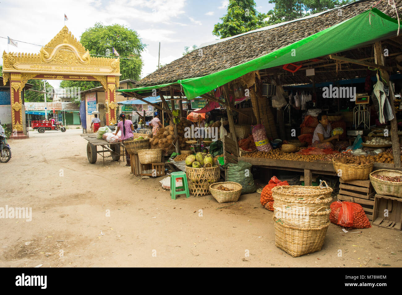 Die BURMESISCHE asiatischen Markt Nyaung U in der Nähe von Bagan, Myanmar. Marktstand verkaufen Obst, Gemüse und Nüsse mit Produkten auf Anzeige in Kisten und Zuckerrohr Korb. Stockfoto