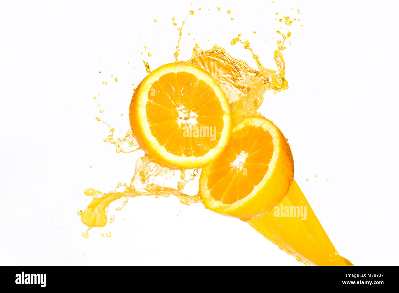 O-Saft spritzt auf halbe Orangen vor einem weißen Hintergrund Stockfoto