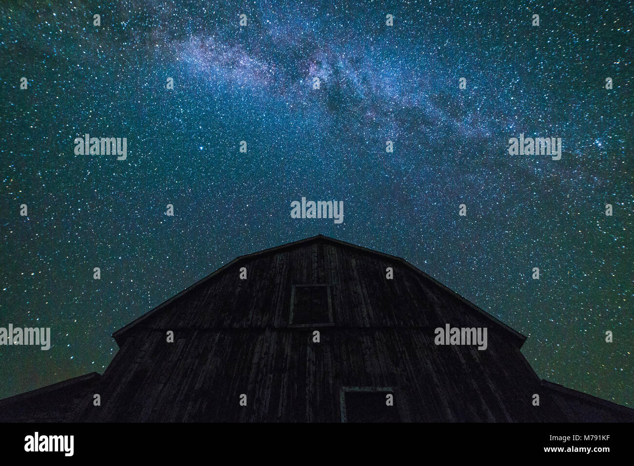 Alte Scheunen und Nebengebäuden mit Sternenhimmel mit Wolken und Milchstraße im Sommer Stockfoto