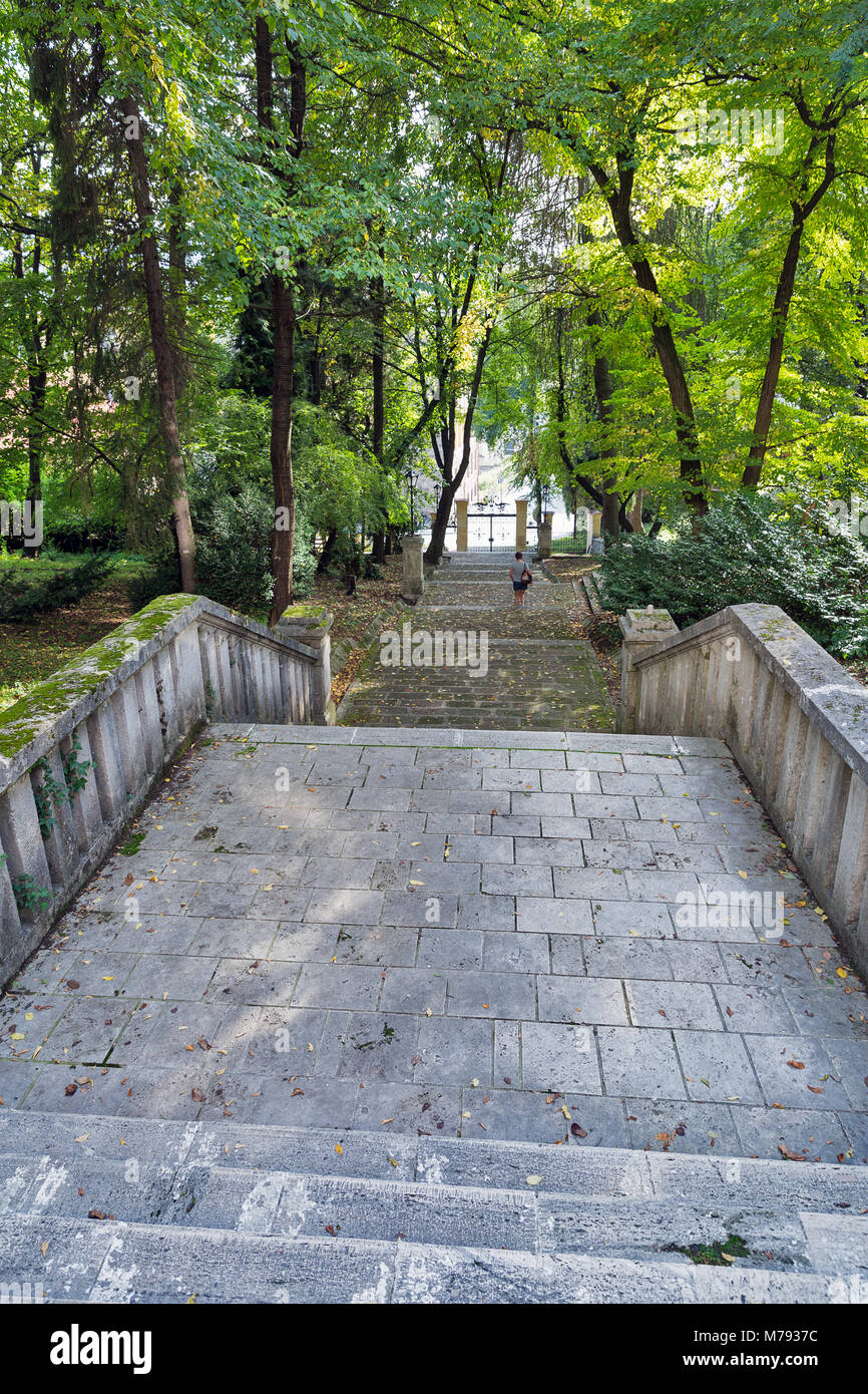 Kaukasische Frau mittleren Alters Spaziergang im alten Park in der Nähe der Schule der Chemie in Banska Stiavnica, Slowakei Stockfoto