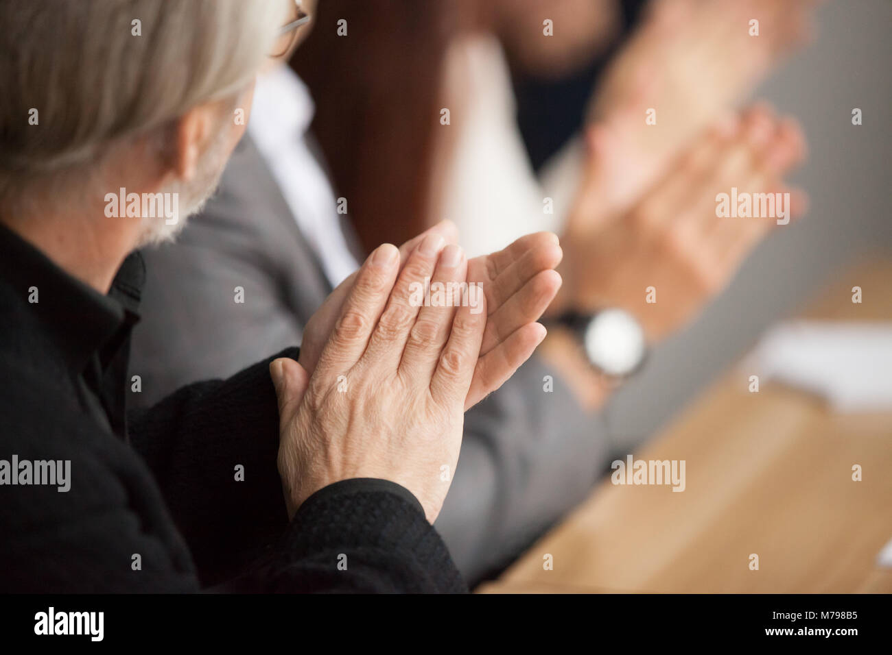 Ältere grauhaarige Geschäftsmann Händeklatschen an conferen Stockfoto