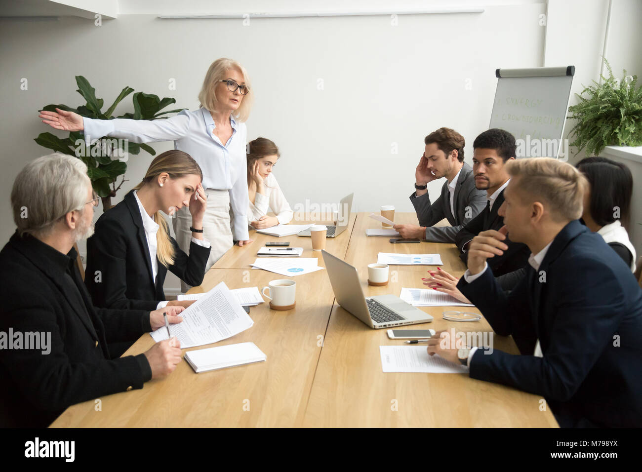 Wütend senior Frau Chef feuert Mitarbeiter im Büro Team Meeting Stockfoto