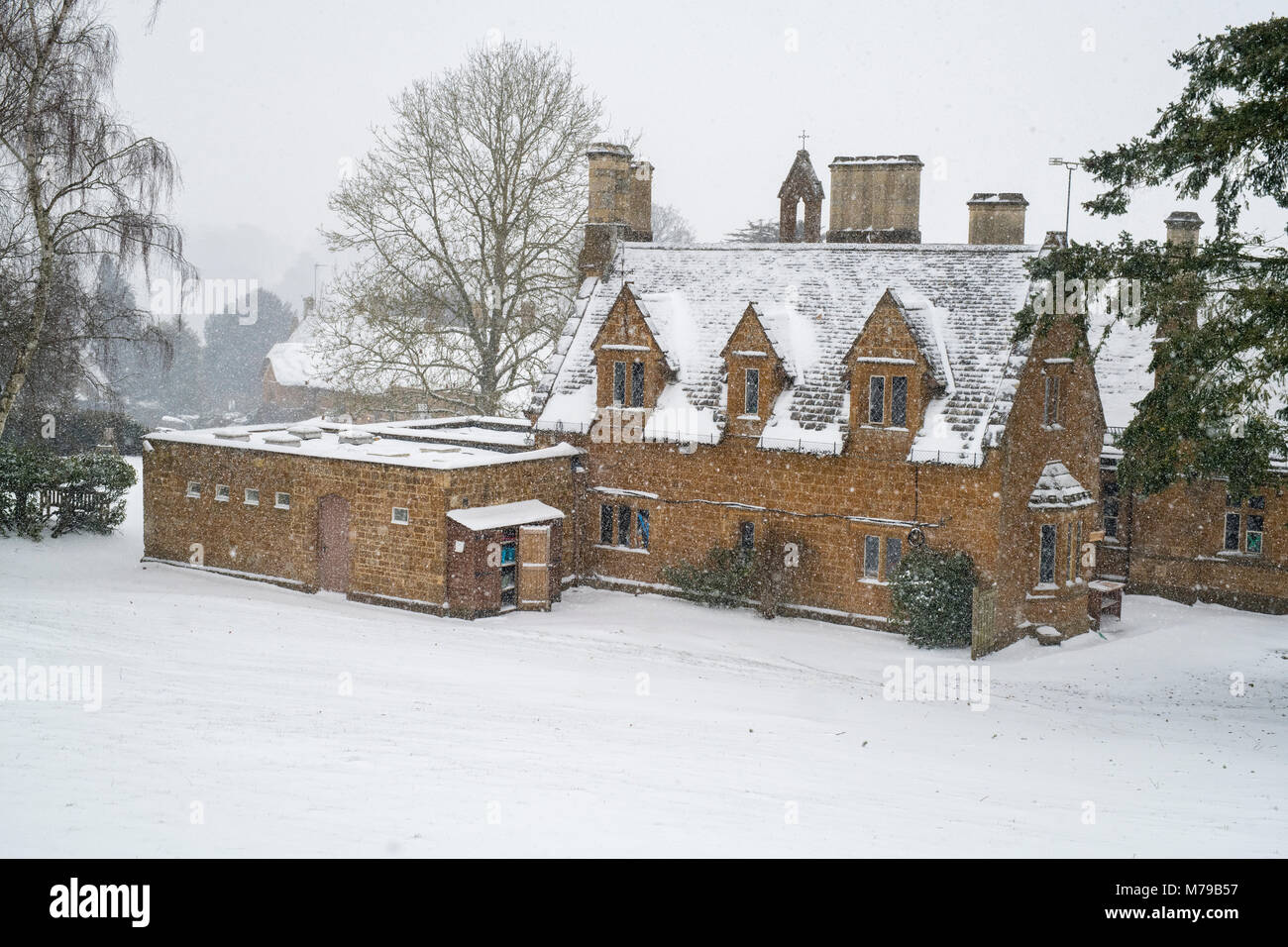Große Tew Grundschule Gebäude im Winter Schnee. Große Tew, Cotswolds, Oxfordshire, England Stockfoto