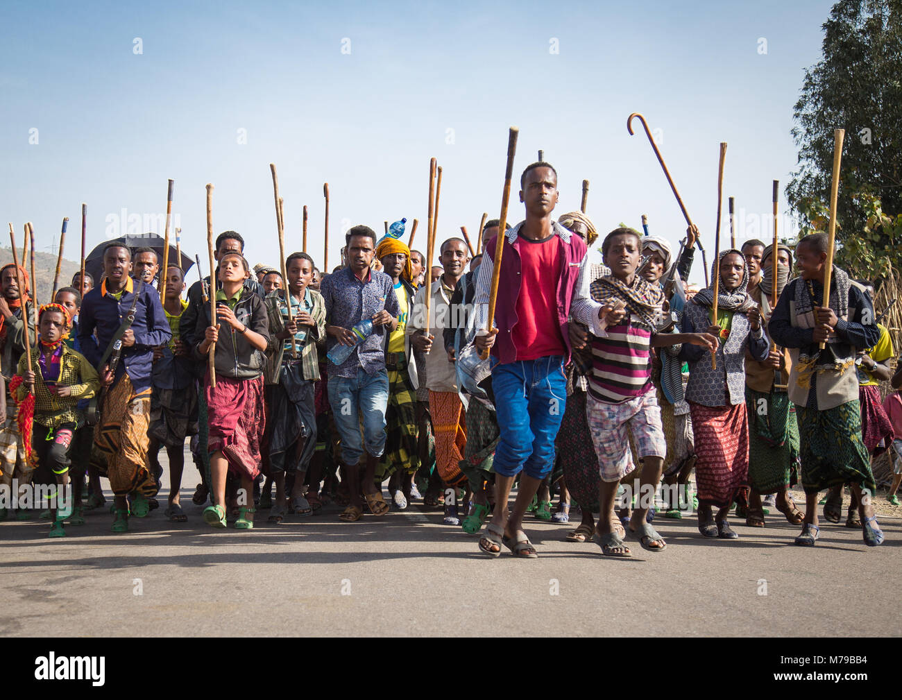 Oromo Männern und Jungen mit Stöcken, Stöcke und Waffen tanzen und fröhlich feiern eine Hochzeit, Oromo region, Sambate, Äthiopien Stockfoto