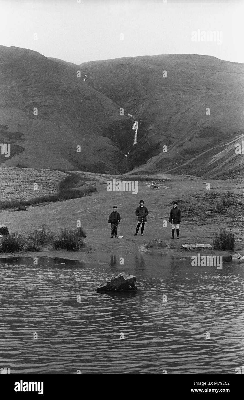 Familie von Wanderern auf howgill Fells mit Cautley Auslauf hinter, Yorkshire Dales, England. Schwarz-weiß Film Foto. MODEL RELEASED Stockfoto