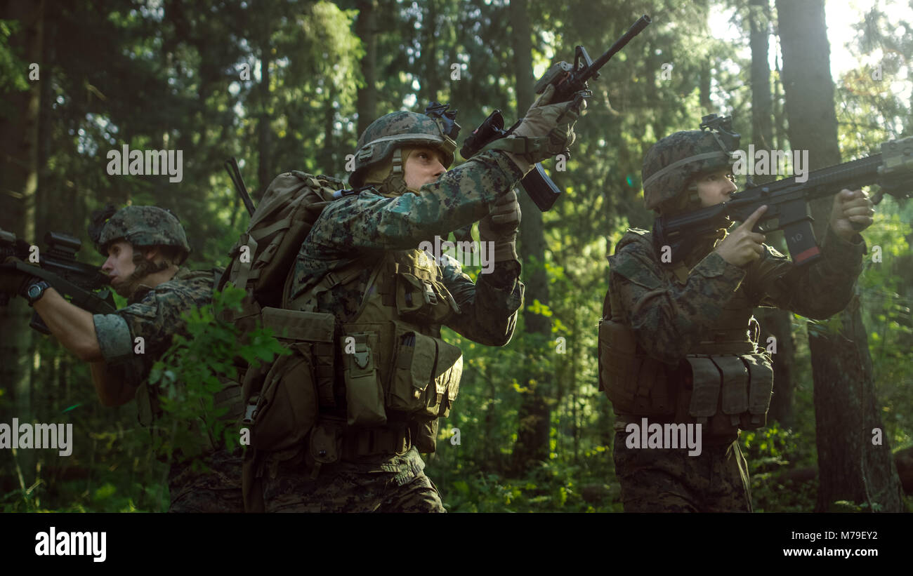 Voll ausgestattete Soldaten tragen Camouflage Einheitliche angreifenden Feind, Gewehre in Anschlag. Militärische Operation handeln, Gruppe durch den Wald läuft Stockfoto