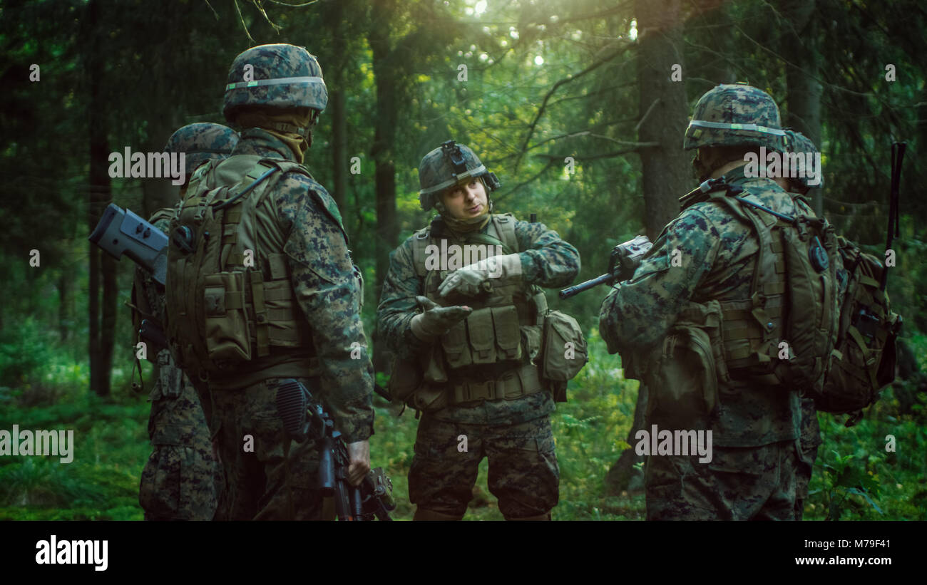 Squad Leader bespricht Militärische Operation Details mit Soldaten, Commander gibt Aufträge. Voll ausgestattete und bewaffneten Soldaten bereit für Mission im Wald Stockfoto
