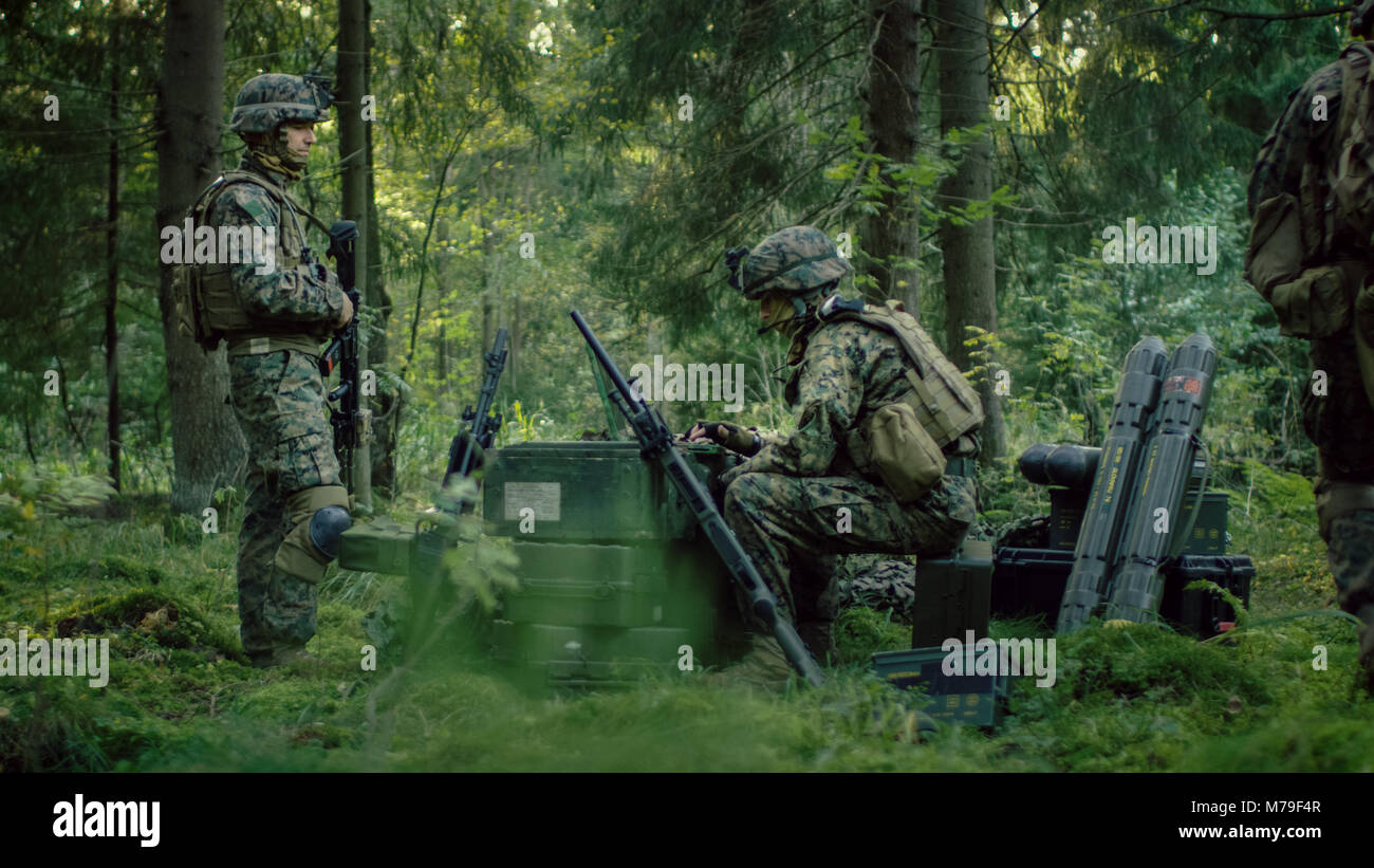 Militärische Inszenierung Base, Chief Army Engineer Sitzen auf den Kisten mit Munition verwendet Armee Grade Laptop Ausgestellt von militärisch-industrielle Komplex. Stockfoto