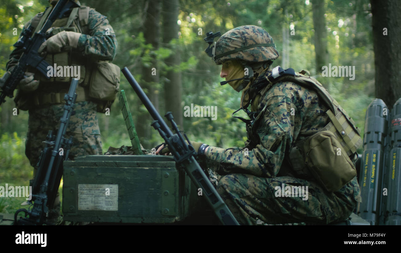 Militärische Inszenierung Base, Chief Army Engineer Sitzen auf den Kisten mit Munition verwendet Armee Grade Laptop Ausgestellt von militärisch-industrielle Komplex. Stockfoto