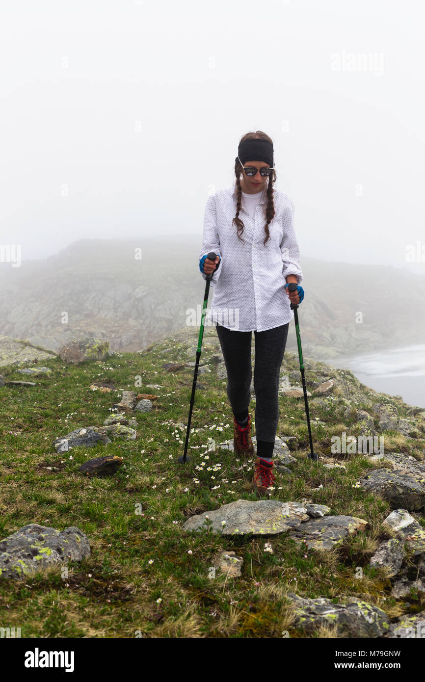 Das Mädchen reiste für einen Spaziergang im felsigen Gelände bei Nebel. Wilde Landschaft mit Wolken. Das Konzept des Lifestyle, Abenteuer, Spaß und rel Stockfoto