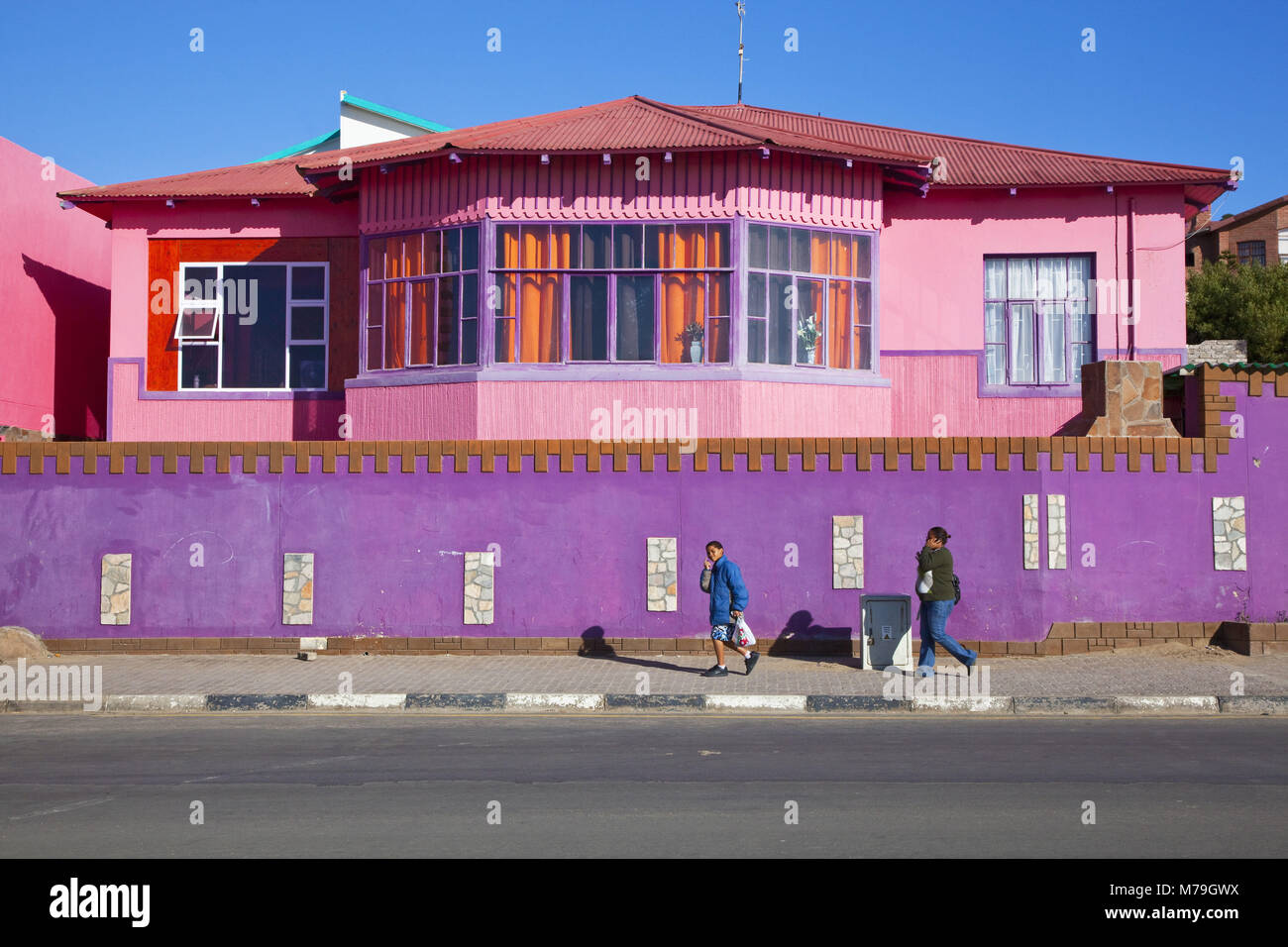 Afrika, Namibia, Lüderitz, Lüderitz Bucht, Wohnhaus, bunt, Haus, Gebäude, Hafen, Hafen, Rosa, Lila, helle, Passanten, Menschen, Einheimische, Sonne, Himmel, blau, Außen, Stockfoto