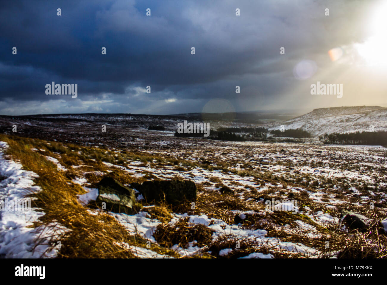 Sonnenstrahlen durch die Wolken an einem verschneiten Tag, Burbage, Peak District Stockfoto